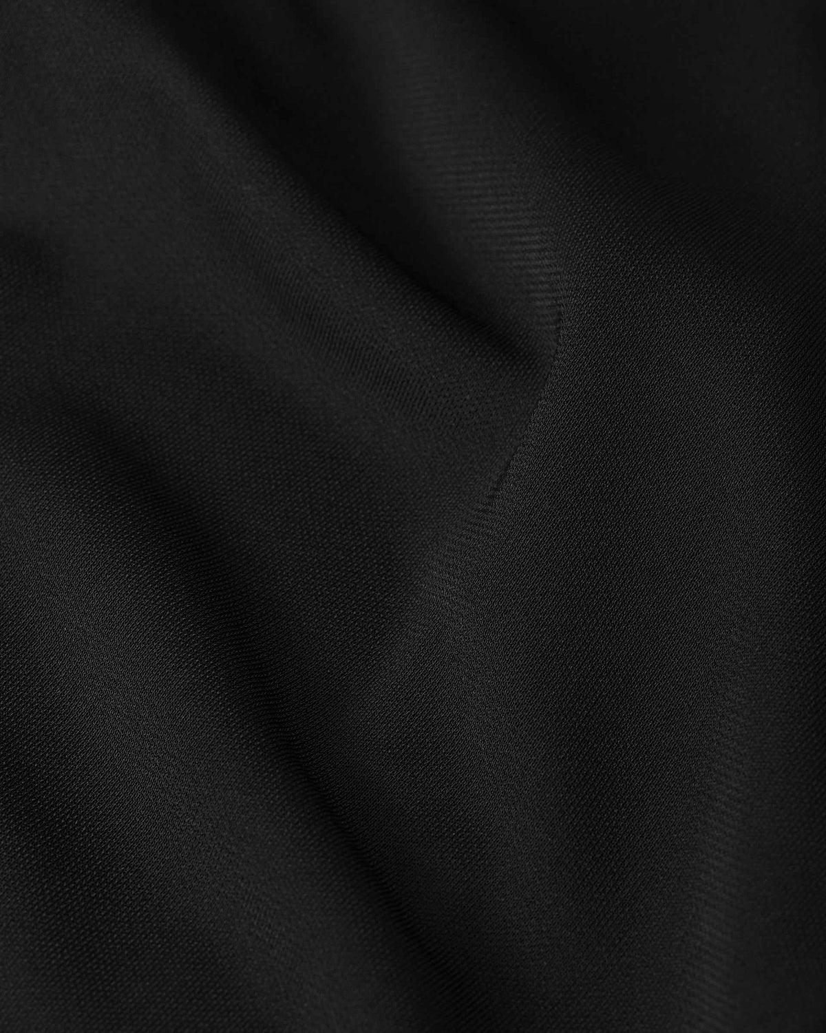 Gentle highlights appear where the black fabric folds, revealing its smooth surface.
