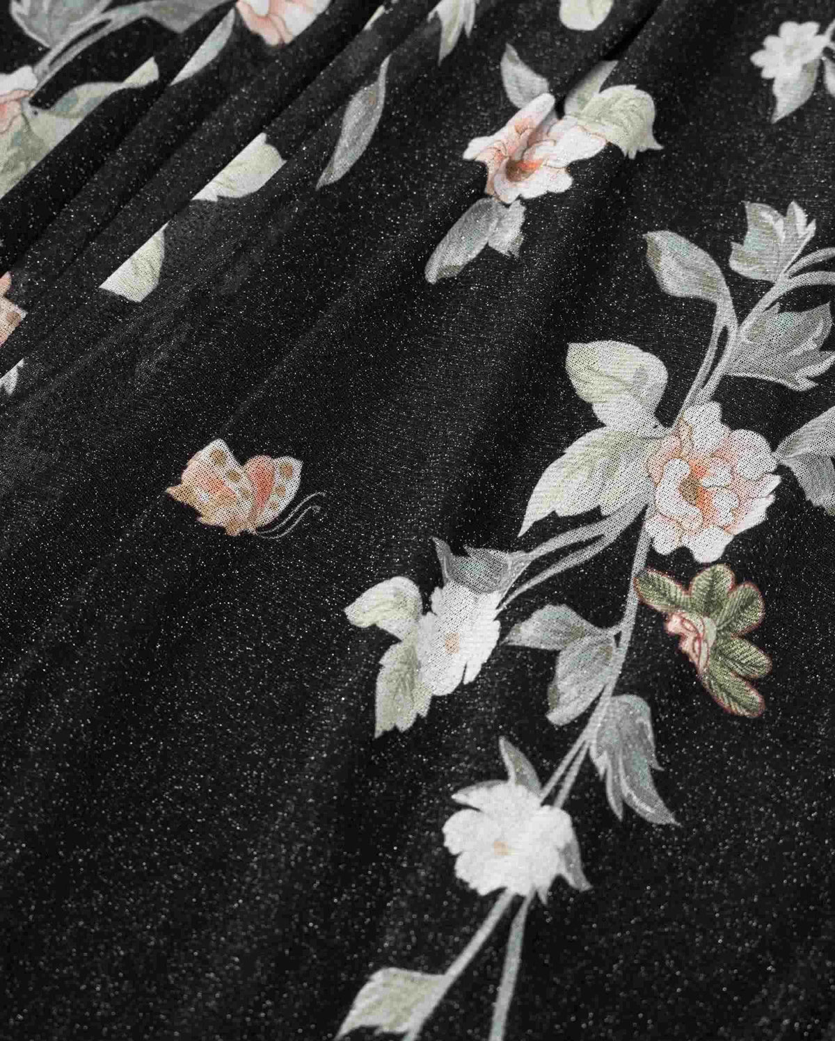 Pale flowers and leaves extend along slender branches across the dark fabric.