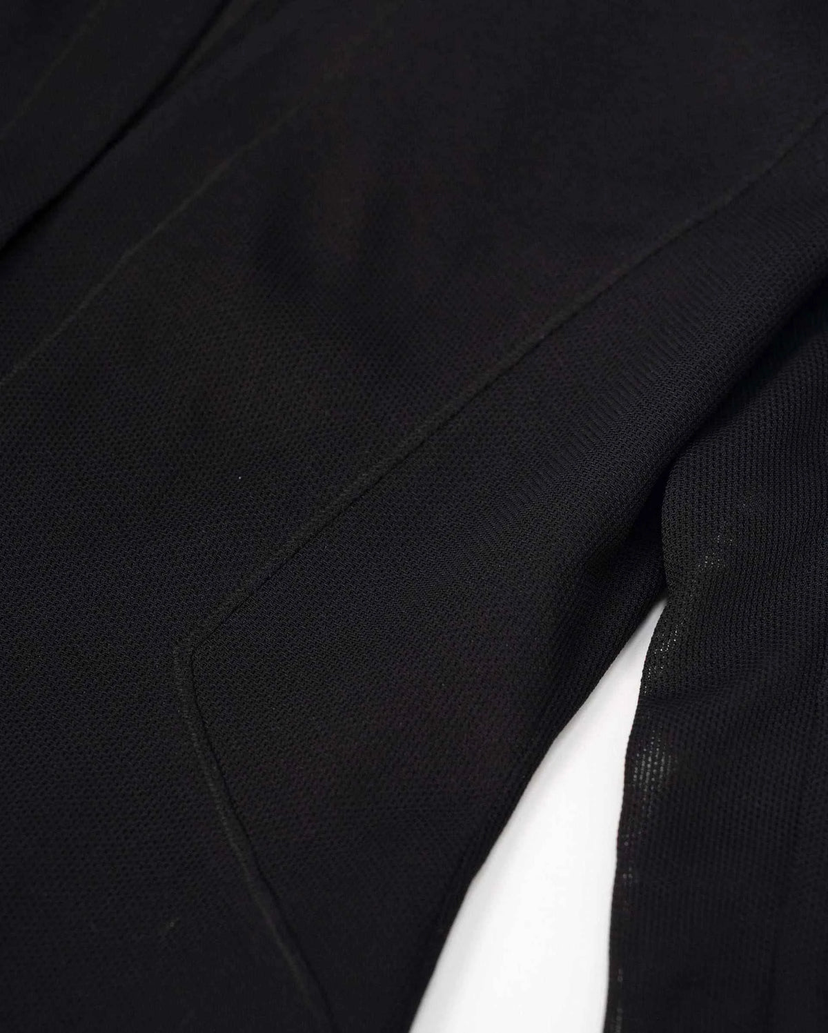 A long seam follows the dark fabric through the body, bringing subtle definition to the tailored shape.