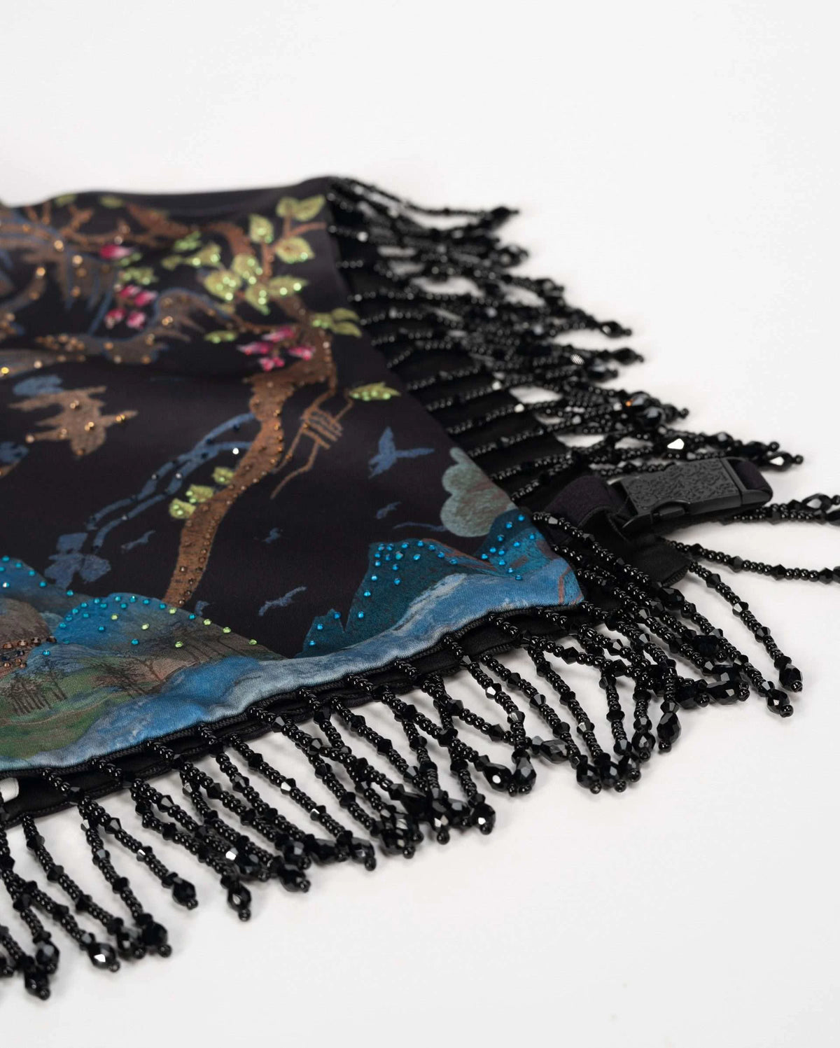 A row of dark fringe hangs beneath the embroidered lower edge.