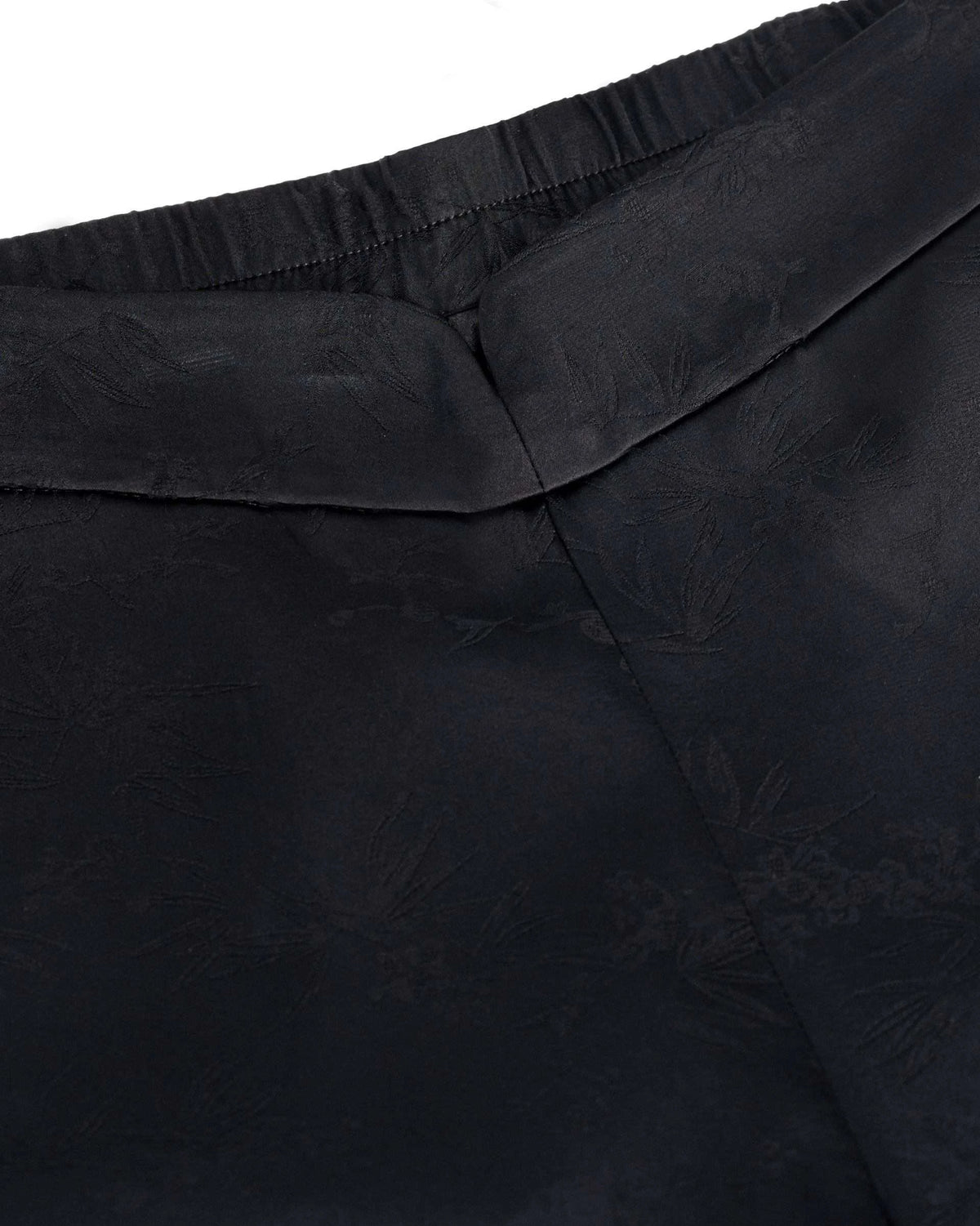 Fine gathering runs along part of the upper band beside the smooth dark fabric.