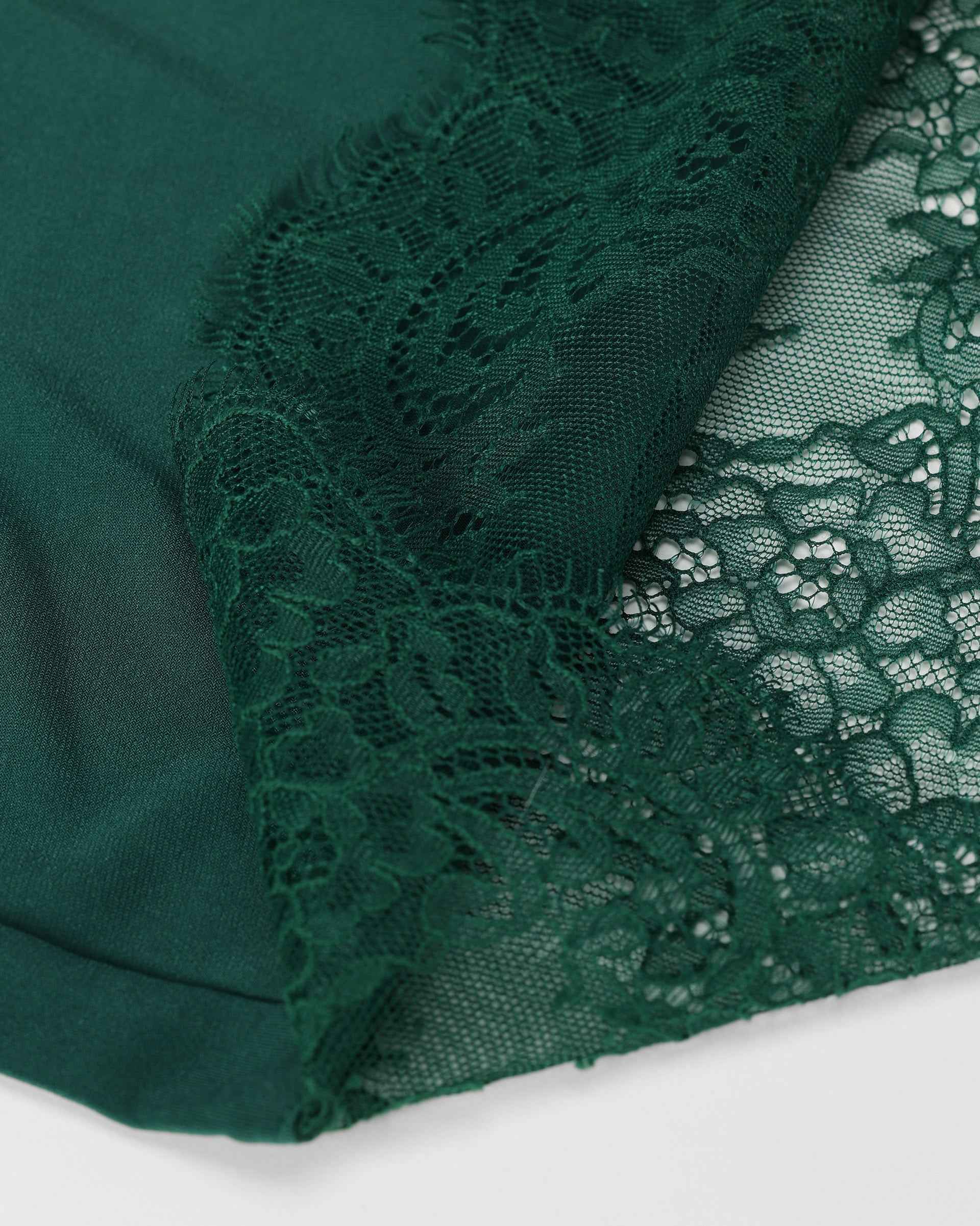 Lace follows the upper edge beside a transparent panel, giving the neckline a fine decorative frame.