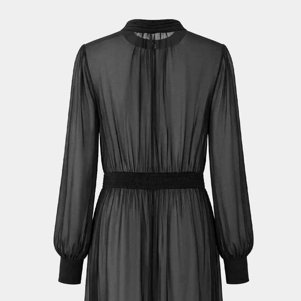 The transparent upper back meets a darker waistline before opening into the long skirt.